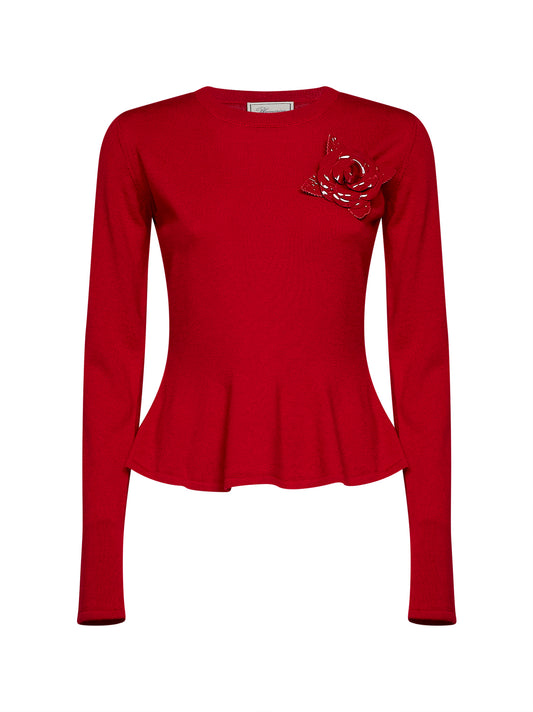 Red wool knit sweater with patent leather rose brooch